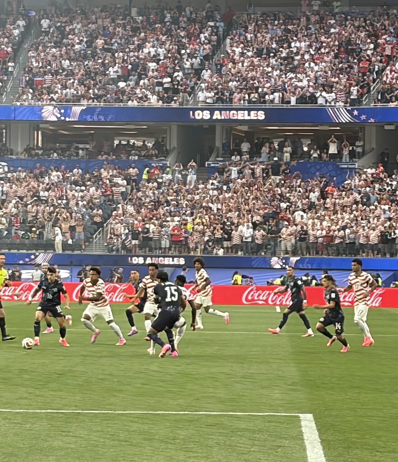United States and Paraguay players on the field at SoFi Stadium, with a home crowd behind them.